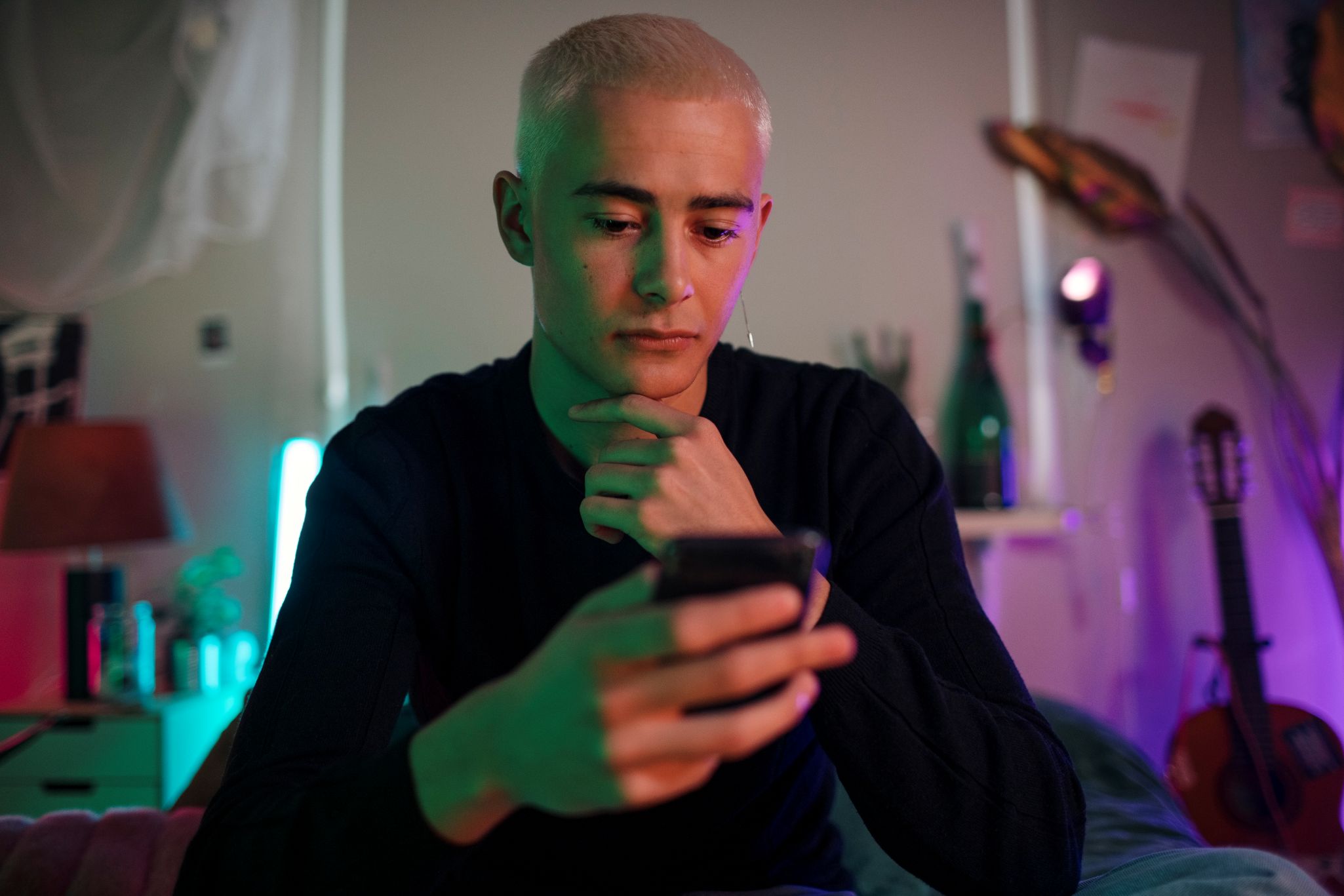 A teen boy looking at his phone, demonstrating AI therapy risks for teens