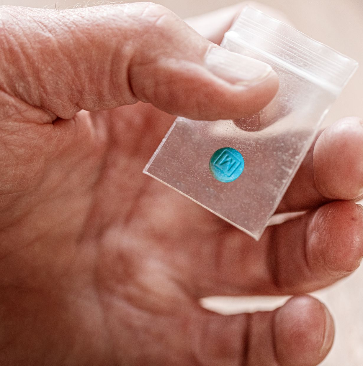 A person holding a pill that could contain orphines, which are new synthentic opioids stronger than fentanyl