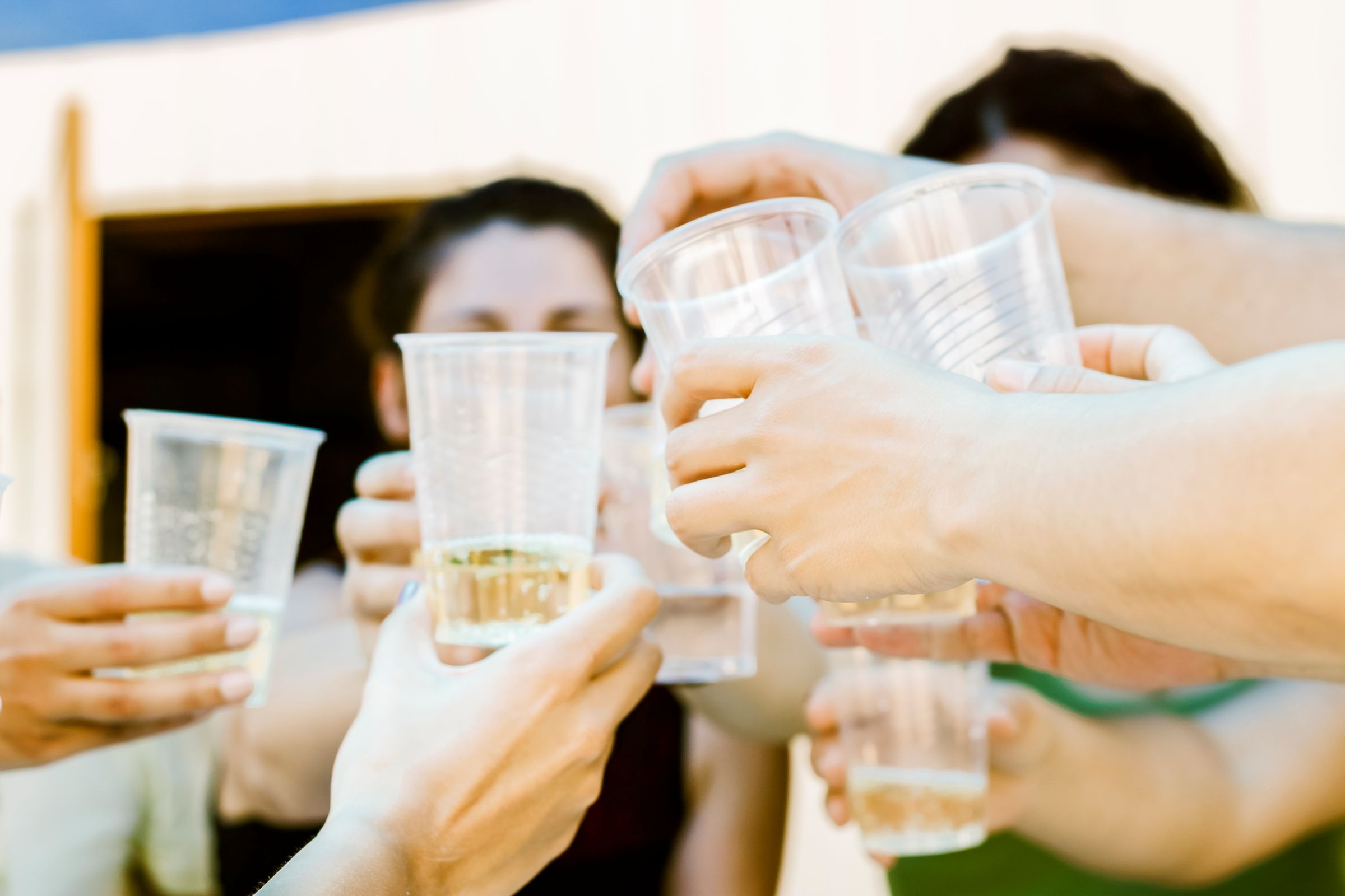 A group of friends makes a toast, representing teen binge drinking