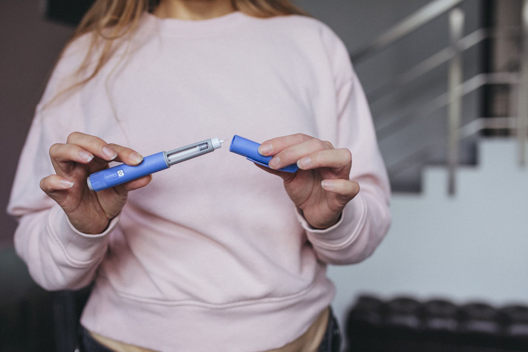 A woman looking at a peptide injection, representing peptides for teens