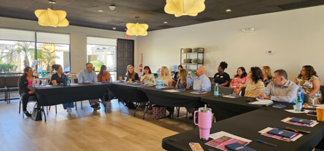 People sitting at table during notMyKid conference