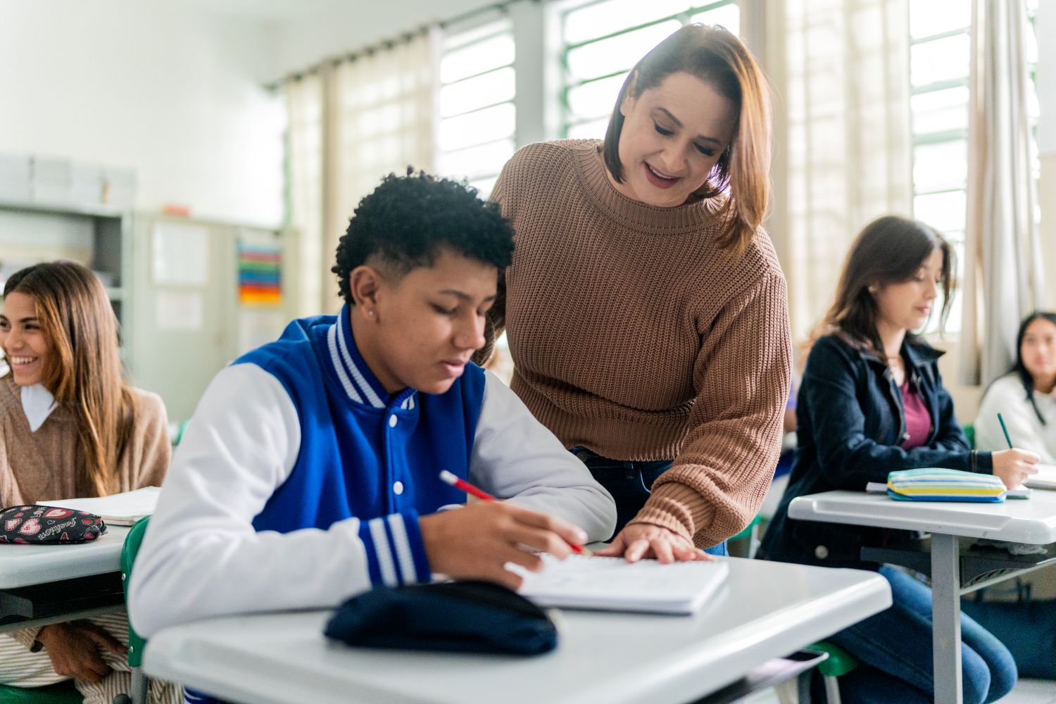 A teacher works with a student, representing how schools respond to student substance use